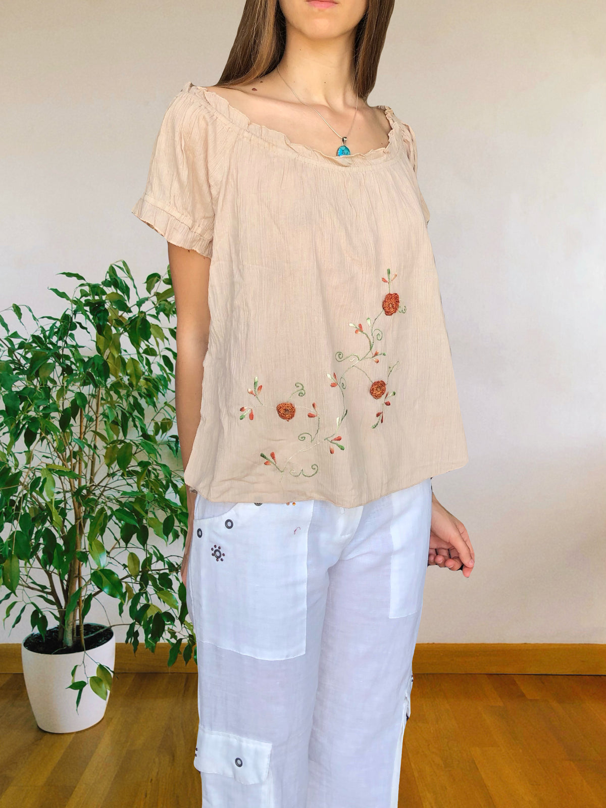 Blusa beige con ricami floreali