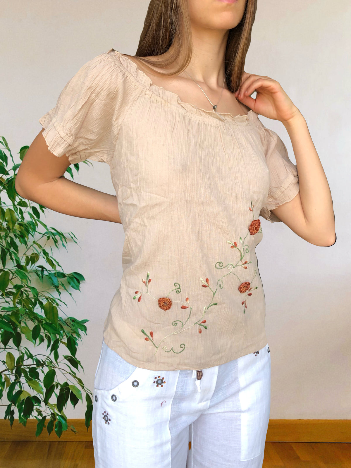 Blusa beige con ricami floreali